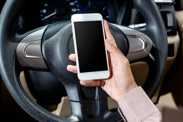 Man holding a mobile phone in the car