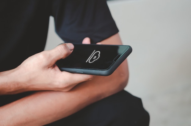 Man holding mobile phone cloud icon.Downloading the social network application online.