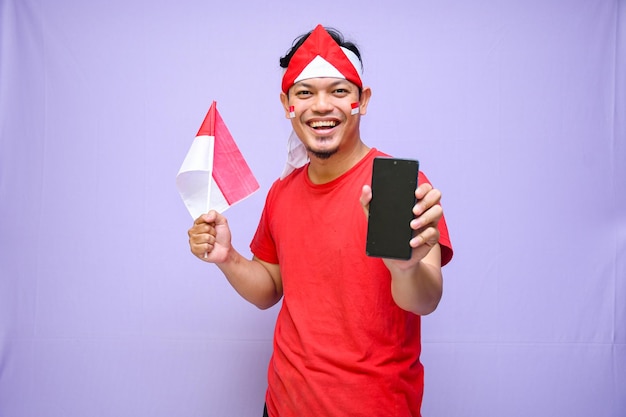 Man holding mobile phone and indonesian flag while celebrating indonesia independence day 17 august