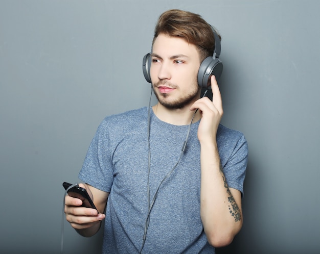 Man holding mobile phone and listening to music