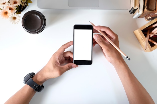 Man holding mockup smartphone on office desk.