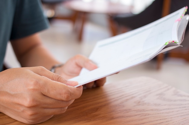 Man holding a notebook on wooden table