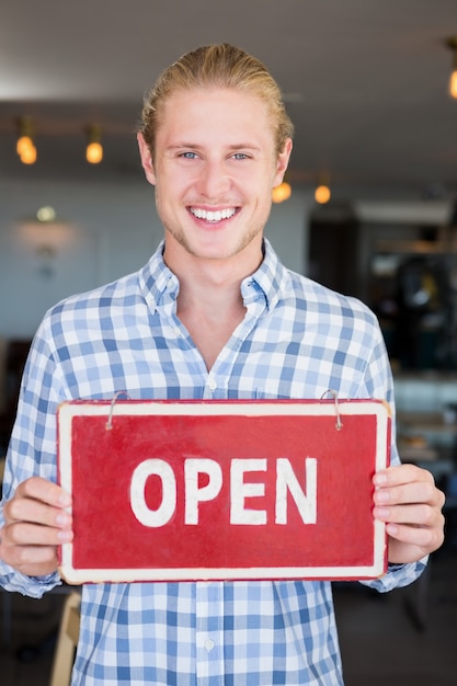 Man holding open signboard