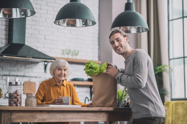 Man holding a package of greens in his hands