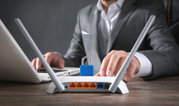 Man holding padlock over internet router. network\
protection