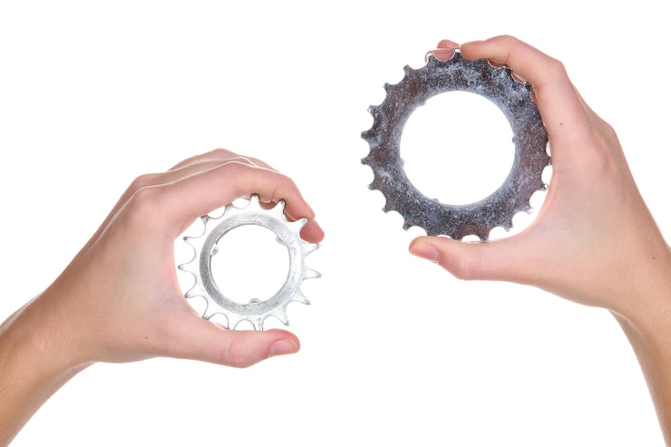 Photo man holding a pair of old metallic cogwheels in his hands
