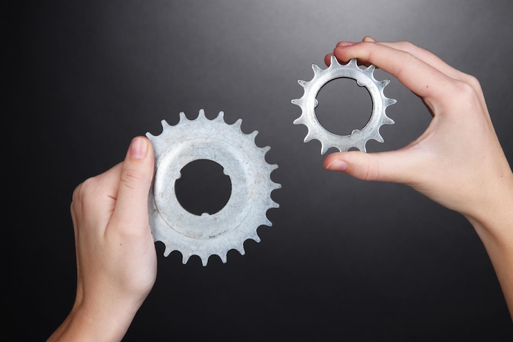 Photo man holding a pair of old metallic cogwheels in his hands