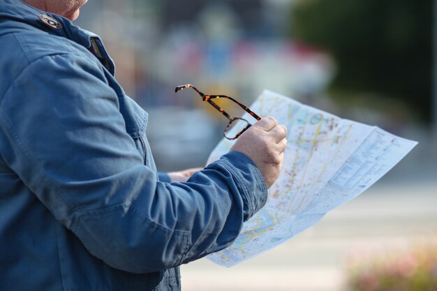 紙の地図を手に持った男。