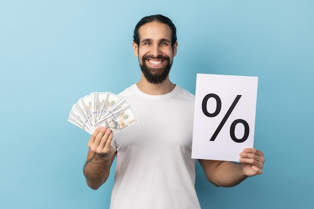 Man holding paper with percent sign inscription and dollars banknotes looking at camera