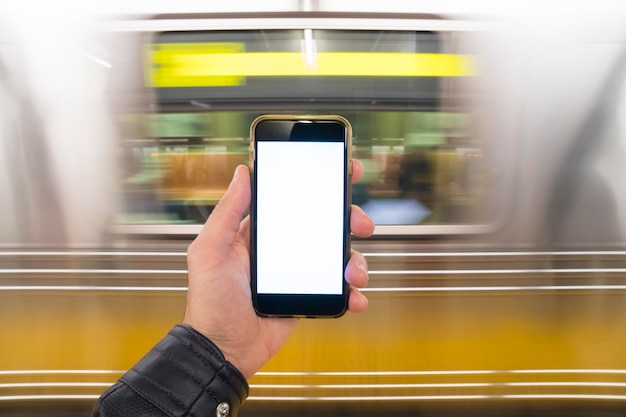 Man holding phone in hand in the subway