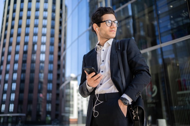 A man holding a phone is a manager an employee in a financial company goes to the office