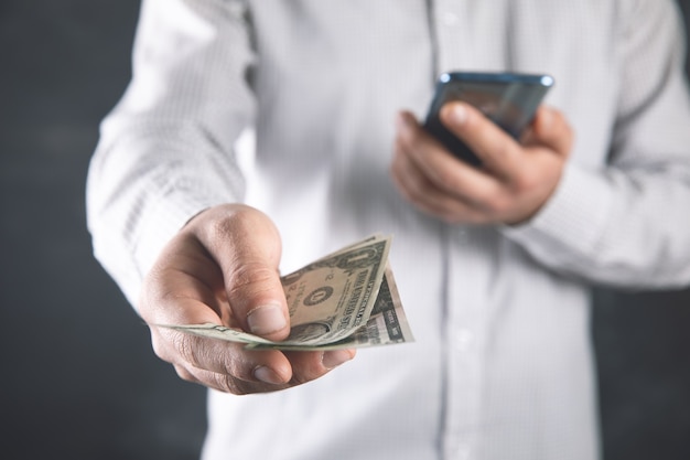 a man holding a phone and money in his hand .