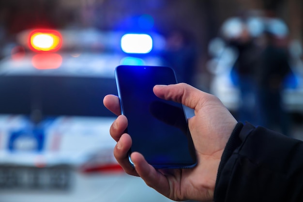 Foto uomo che tiene il telefono in strada