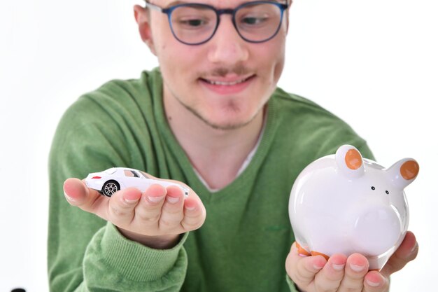 man holding Piggy bank and toy car