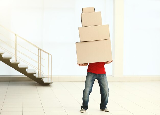 Man holding pile of carton boxes in the room