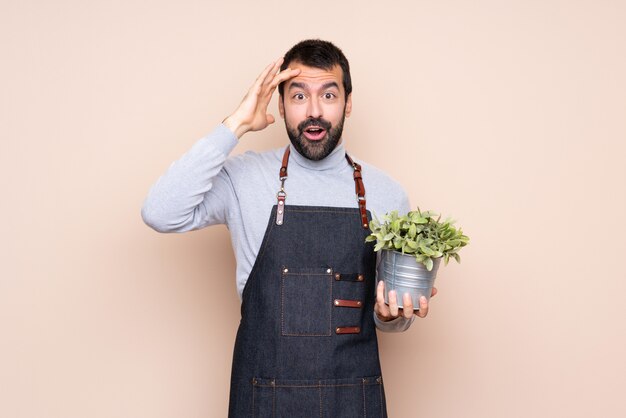 Man holding a plant has just realized something and has intending the solution