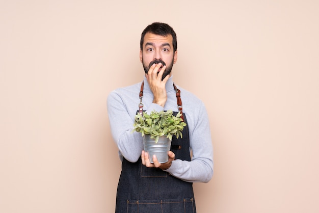 右を見ながら驚いてショックを受けた分離壁を越えて植物を保持している男