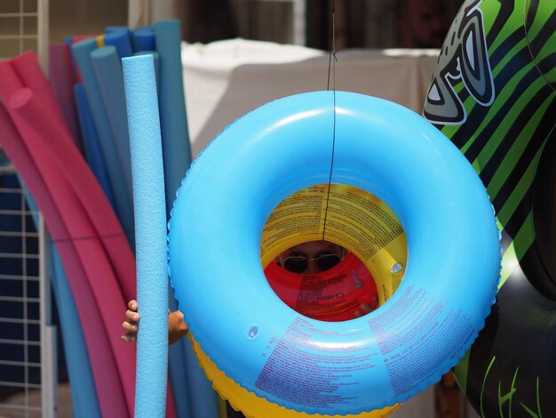 Photo man holding pool rafts while standing outdoors