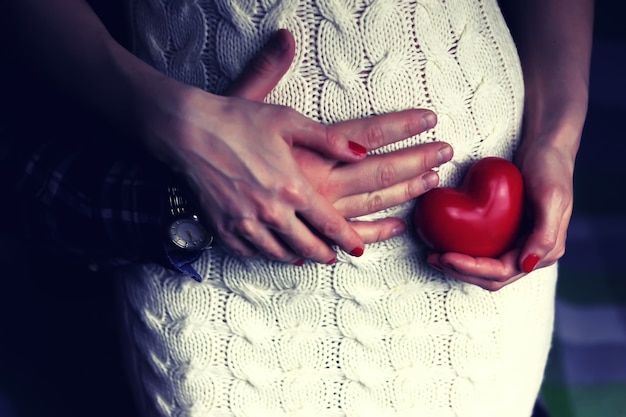 Man holding pregnant women with heart shape