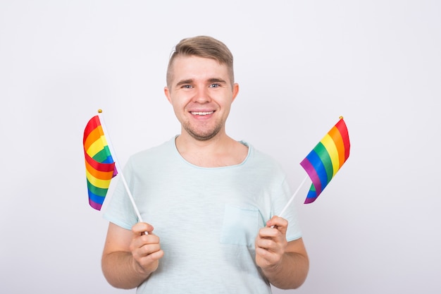 Man holding rainbow flags in his hands