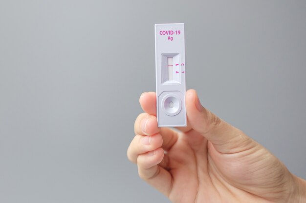 Man holding Rapid Antigen Test kit with Negative result during swab COVID-19 testing. Coronavirus Self nasal or Home test, Lockdown and Home Isolation concept