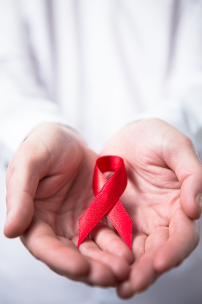 Man holding red aids ribbon