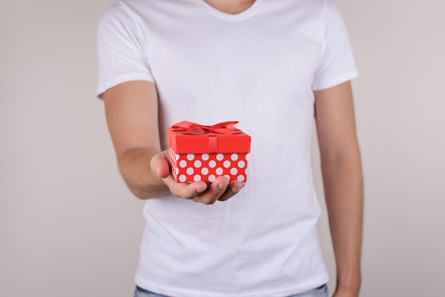 Man holding red giftbox on isolated grey background