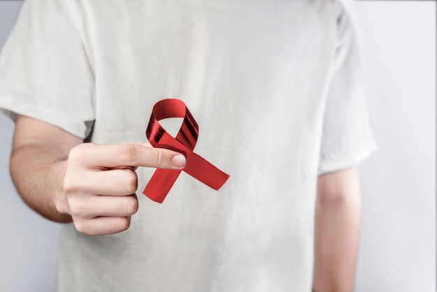 Man holding red ribbon Hiv Aids