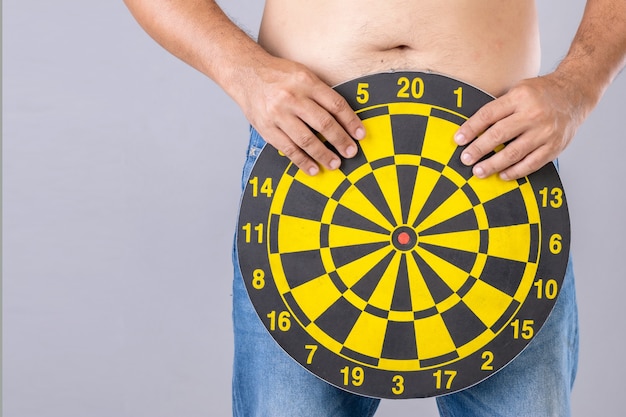 Man holding round yellow Dartboard