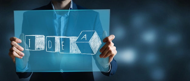 A man holding a screen with the inscription idea in cubes