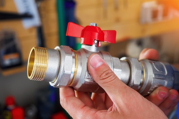 Man holding semirotating faucet for plumbing in his hand Selection of tap for water heating on pipe Closeup