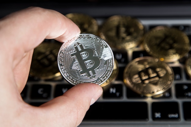 A man holding a silver bitcoin