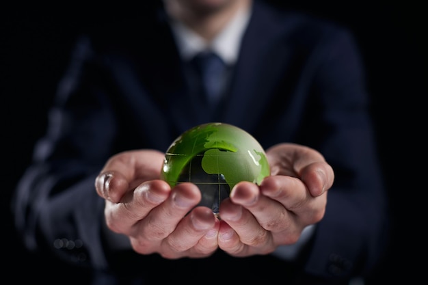 Man holding a small green glass ball generative ai