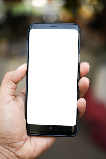 Man holding smart phone on blurred background