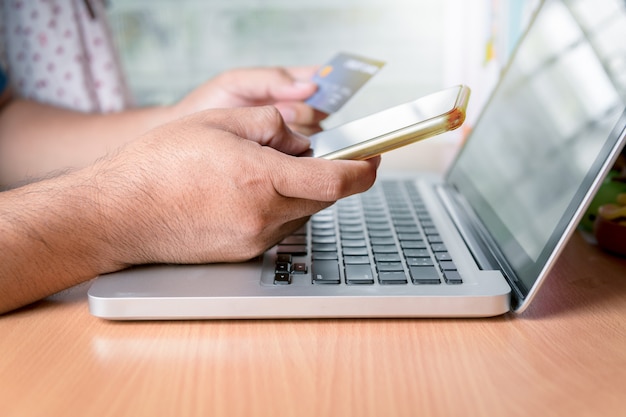 Man holding a smartphone and a credit card