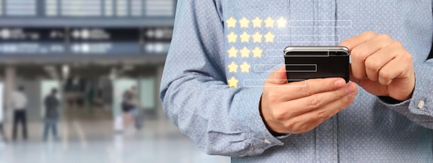 Photo man holding smartphone device and touching screen with five star rating feedback icon