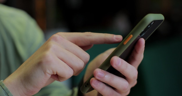 Man holding a smartphone in his hands and using an app Hand holding smartphone device and touching screen