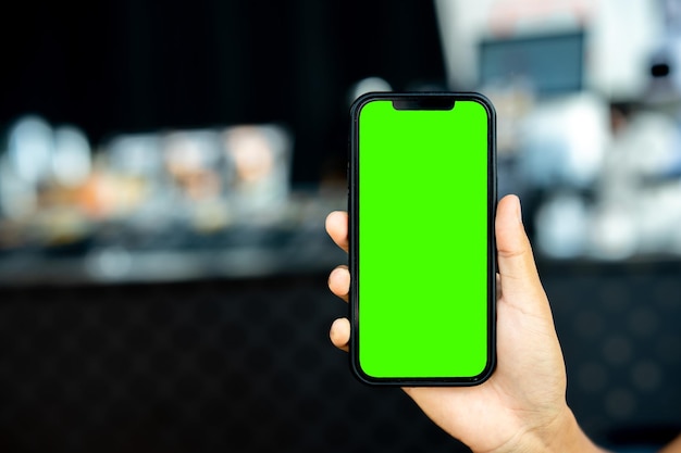 Man holding a smartphone with simulated green screen