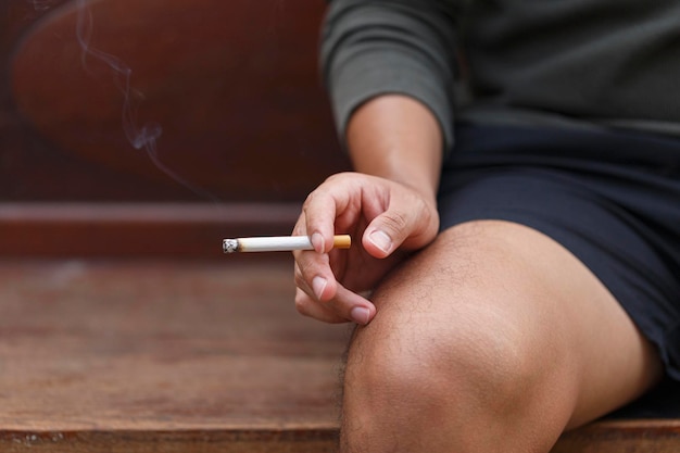 Man holding smoking a cigarette in hand