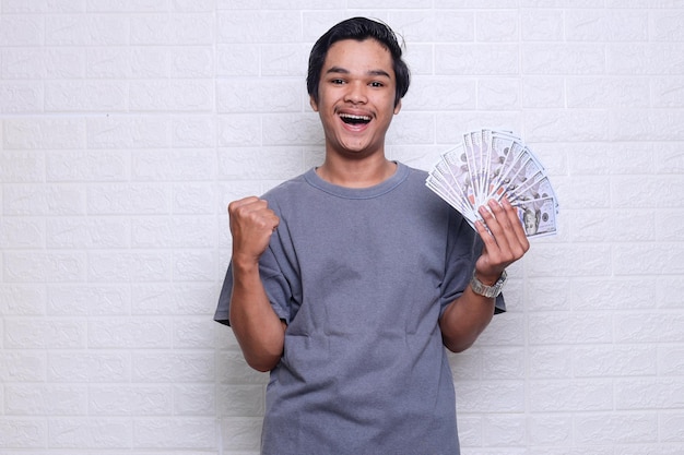 A man holding a stack of money in his hand and a fist is showing a gesture that says'$ 1 '