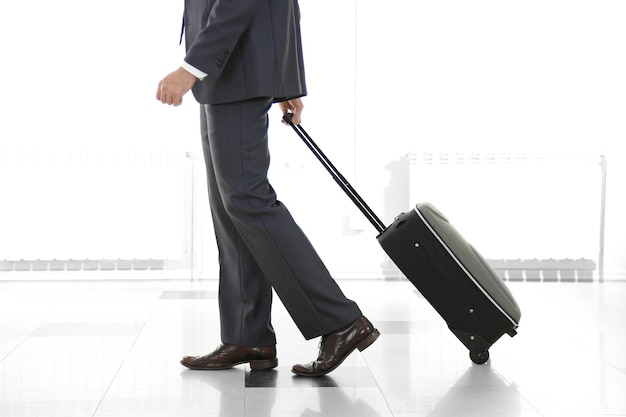 Man holding suitcase on light background