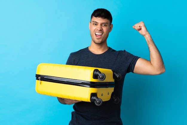 Man holding a suitcase in studio