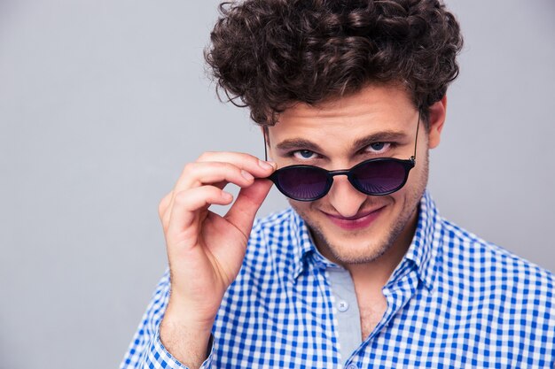 Man holding sunglasses and looking at camera