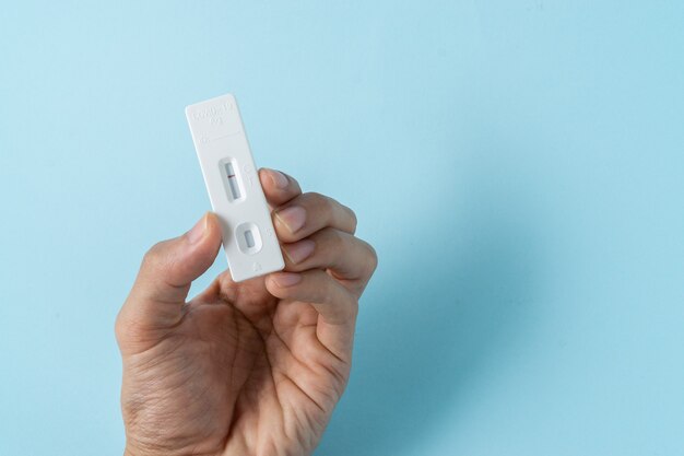 A man holding test kit for viral disease COVID-19 2019-nCoV. Negative test result by using rapid test device for COVID-19.