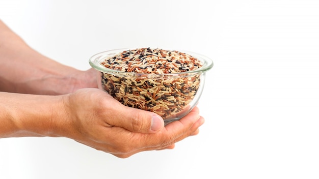 Man holding three colors (red, black, and brown) rice.