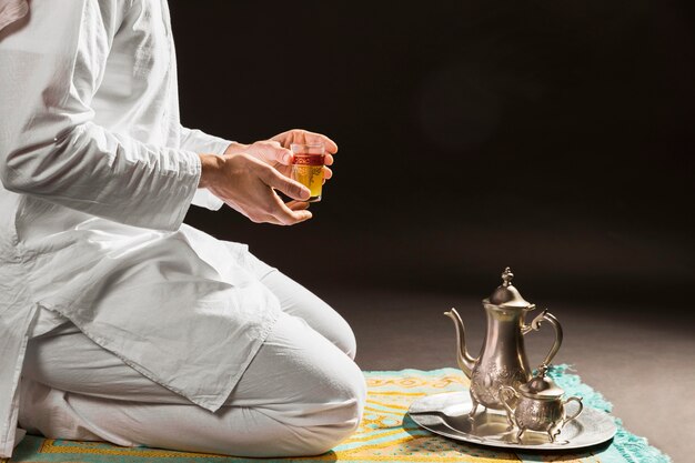 Man holding traditional arabic hot tea in a cup