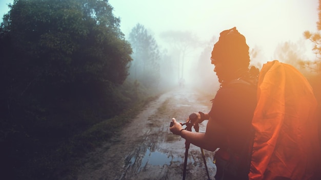 Photo man holding tripod while standing on road against sky