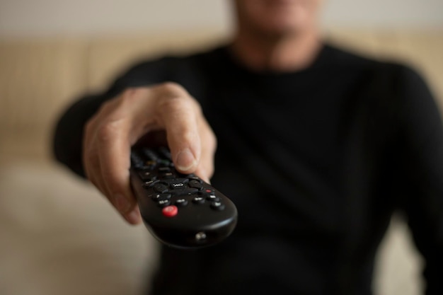 Man holding TV remote control