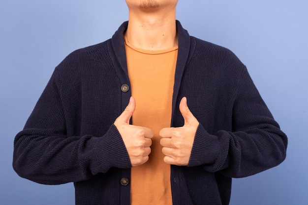 man holding two thumbs up on his chest