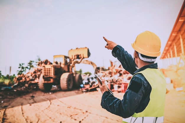 写真 空に向かって街の建設現場で傘を握っている男